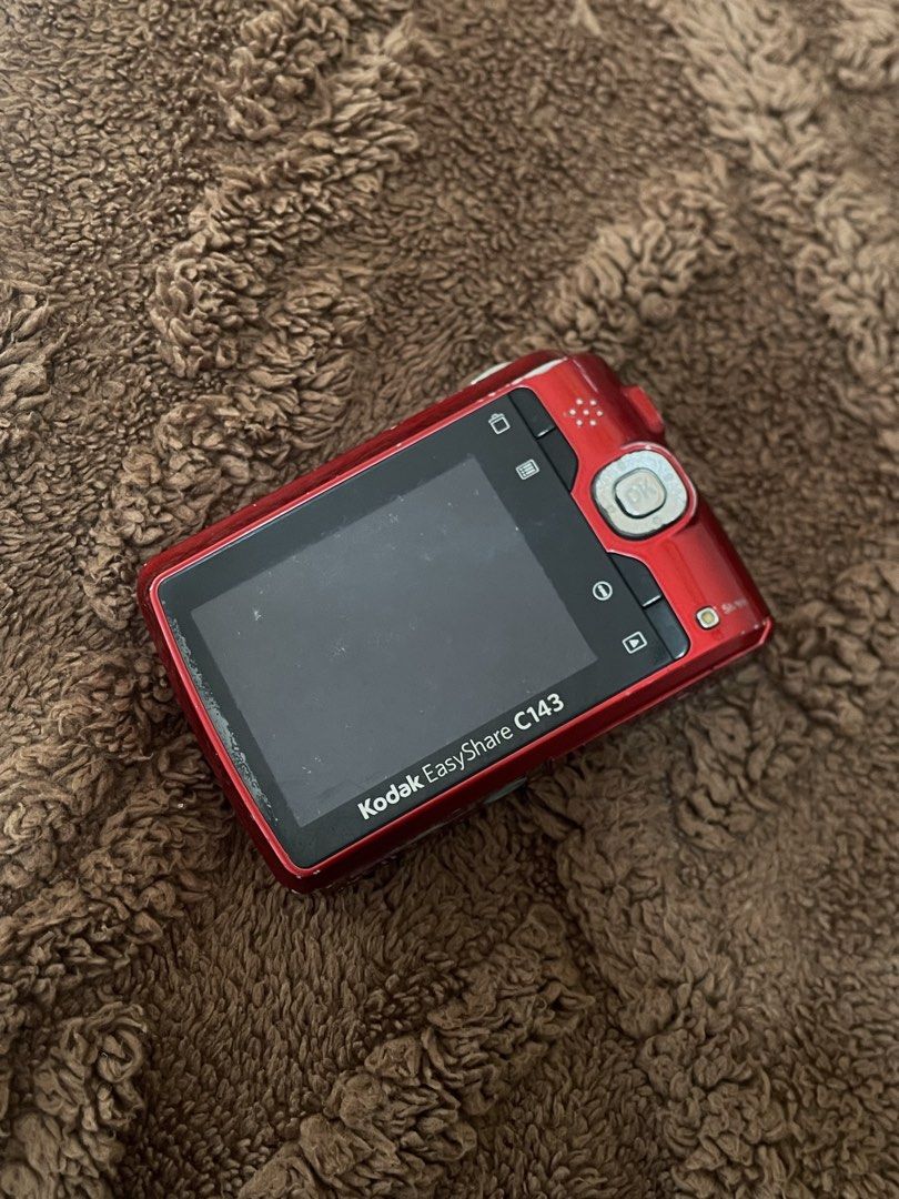 KODAK EASYSHARE C143 (Category: Cameras) located in Manila. Submitted by may_finds (Listing ID 1459624995, Image 2). Description: ✦ 📷 KODAK EASYSHARE C143 **in Red** — Released in 2010 💰 **PRICE: ₱1,300 (from ₱1,500) ✧ Compact, portable, and lightweight. ┆ ⤿ **FOR REPAIR / AS IS** ⓘ **Issues:** — Slightly blurry output — Battery door needs tape — Mild LCD burn (doesn't affect the output and is tolerable) ✦ **Inclusions:** — Unit — Paper bag — C