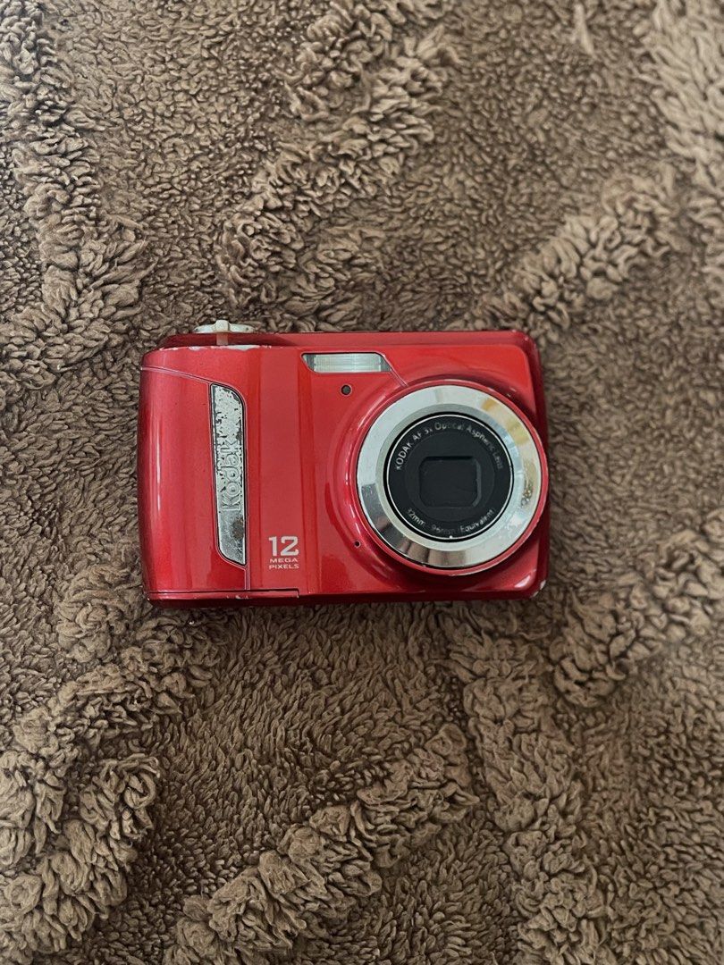 KODAK EASYSHARE C143 (Category: Cameras) located in Manila. Submitted by may_finds (Listing ID 1459624995, Image 1). Description: ✦ 📷 KODAK EASYSHARE C143 **in Red** — Released in 2010 💰 **PRICE: ₱1,300 (from ₱1,500) ✧ Compact, portable, and lightweight. ┆ ⤿ **FOR REPAIR / AS IS** ⓘ **Issues:** — Slightly blurry output — Battery door needs tape — Mild LCD burn (doesn't affect the output and is tolerable) ✦ **Inclusions:** — Unit — Paper bag — C