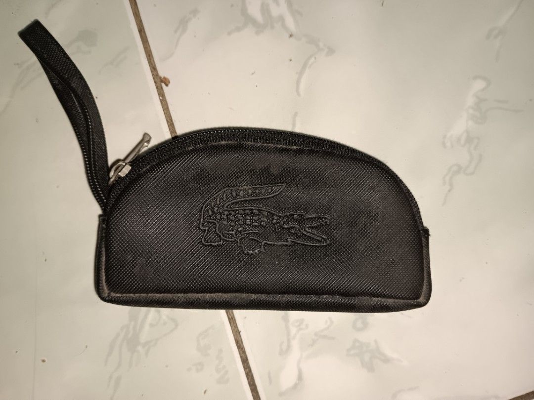 Lacoste Black Coin Pouch with Wrist Strap (Category: Purses & Pouches) located in Manila. Submitted by caaths_collection (Listing ID 1459612413, Image 1). Description: - Black Lacoste Pouch - Zipper closure for secure storage - Convenient small wrist strap - Iconic embossed crocodile logo on the front - Ideal for organizing coins, cards, or small essentials - Compact and easy to carry - preloved.