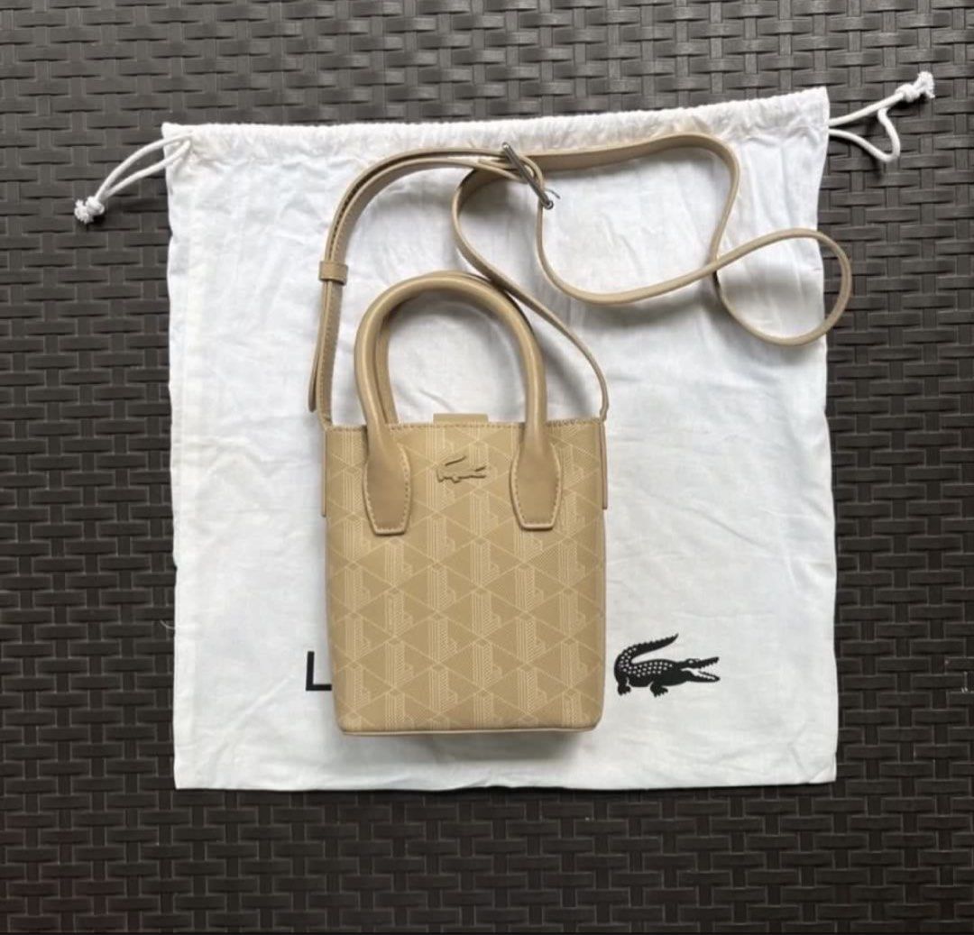 Lacoste Satchel Beige Monogram (Category: Luxury Bags & Wallets) located in Silang. Submitted by wearchiangmai__ (Listing ID 1459611843, Image 1). Description: - Authentic Lacoste bag - Beige color with signature monogram pattern - Vertical mini size - Top handles - Long adjustable strap - Comes with original dust bag and tags - Ideal for carrying essentials.