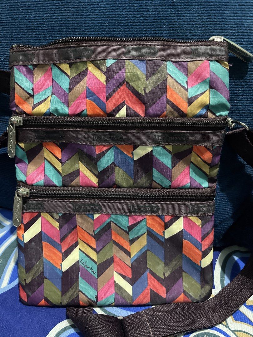 LeSportsac Pouch with Colorful Geometric Pattern (Category: Purses & Pouches) located in Manila. Submitted by edensy (Listing ID 1459640417, Image 1). Description: - Cute LeSportsac pouch with a vibrant geometric design. - Features multiple zippered compartments for excellent organization. - Adjustable strap allows for crossbody or shoulder wear. - Ideal for travel or carrying everyday essentials. - Zippers are smooth and functional. - Pouch is c