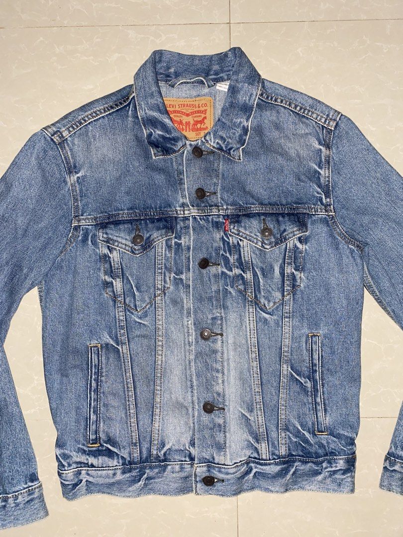 Levi's Denim Jacket - Size S (Category: Coats, Jackets and Outerwear) located in Placer. Submitted by roro9822 (Listing ID 1459651953, Image 3). Description: - Classic Levi's blue denim jacket - Iconic red tab detail - Button closure - Two chest pockets and two side pockets - Ideal for layering - Versatile addition to any wardrobe.