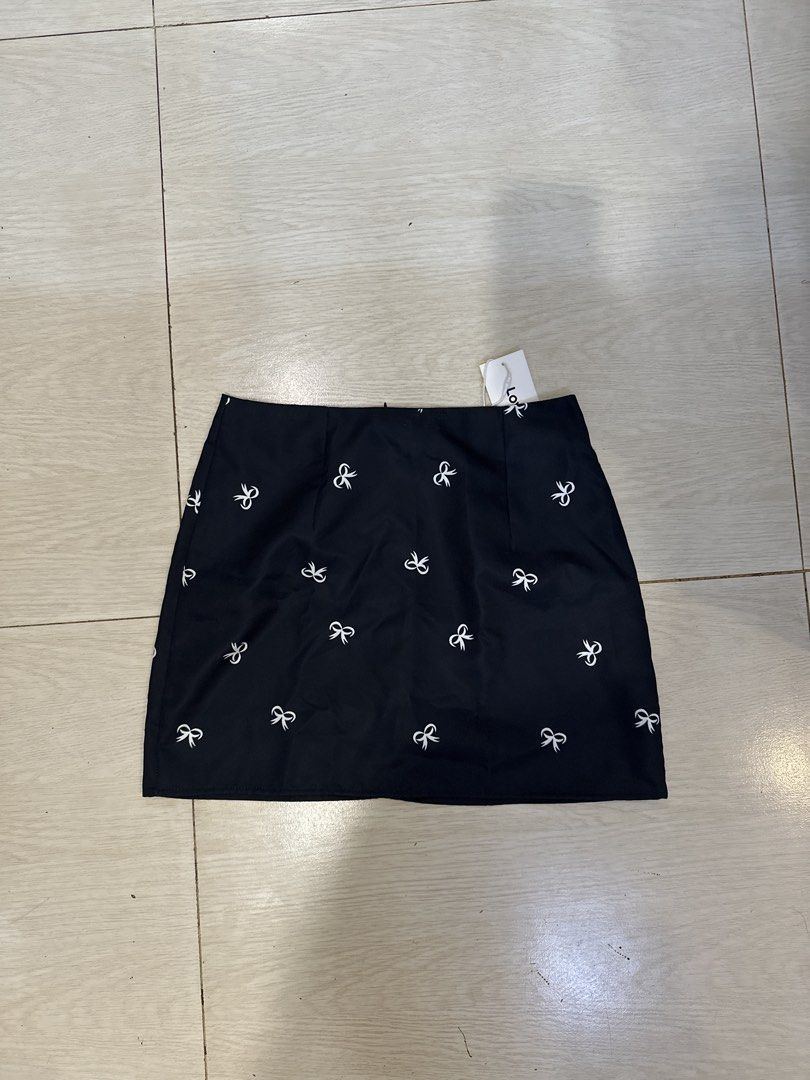 Lovito Black Skirt with White Bow Print (Category: Skirts) located in Rizal. Submitted by rann1121 (Listing ID 1459606214, Image 1). Description: - Adorable black mini skirt featuring a charming all-over white bow print. - Convenient side zipper for easy wear. - Crafted from 100% polyester for a smooth feel. - Easy care instructions: Machine wash, do not bleach, tumble dry on low heat, and iron on low heat. - Made in China..