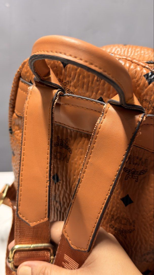 MCM Visetos Mini Backpack Cognac Studded (Category: Backpacks) located in Manila. Submitted by faye_preloved (Listing ID 1459604250, Image 3). Description: - Authentic MCM mini backpack in cognac Visetos - Iconic all-over MCM logo print - Gold-tone hardware and stud details on sides - Adjustable shoulder straps - Top handle - Front zip pocket - Interior pocket - Ideal for everyday use.