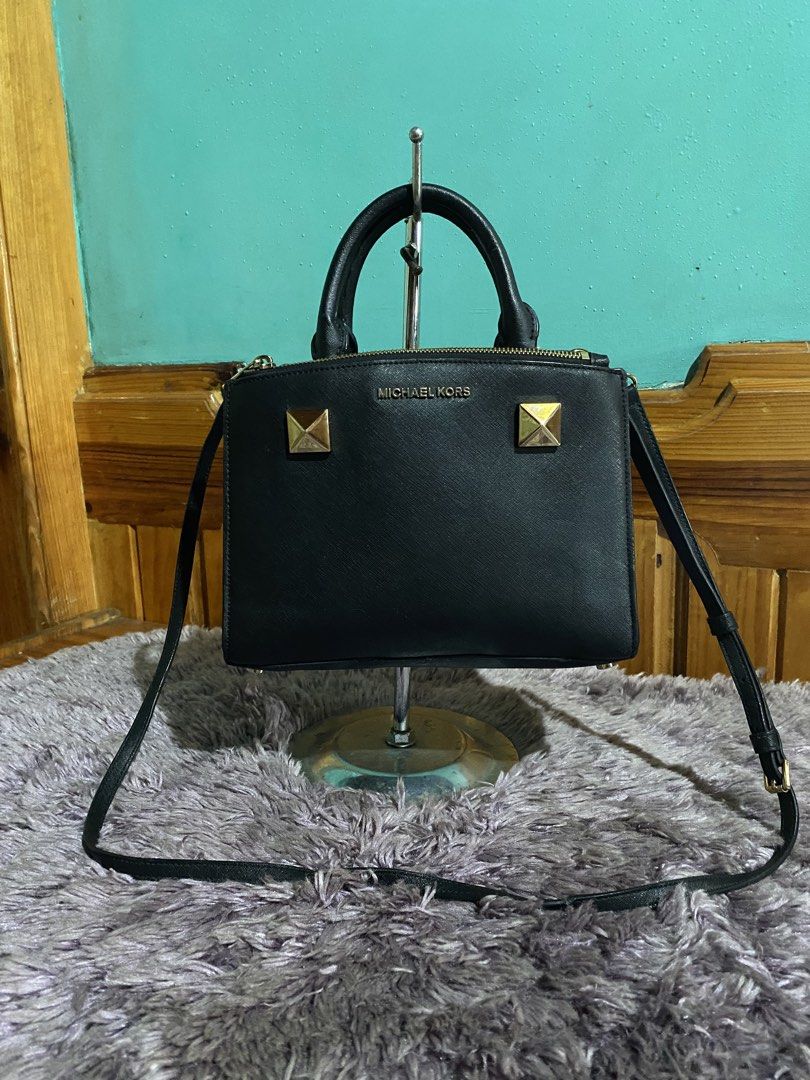 Michael Kors Black Leather Studded Satchel Handbag (Category: Luxury Bags & Wallets) located in La Trinidad. Submitted by kinleyky (Listing ID 1459617704, Image 1). Description: - Authentic Michael Kors satchel bag in classic black. - Crafted from premium textured leather. - Stylish gold stud details on the front. - Versatile carrying options: top handles and a detachable crossbody strap. - Secure zipper closure to keep your belongings safe. - Am