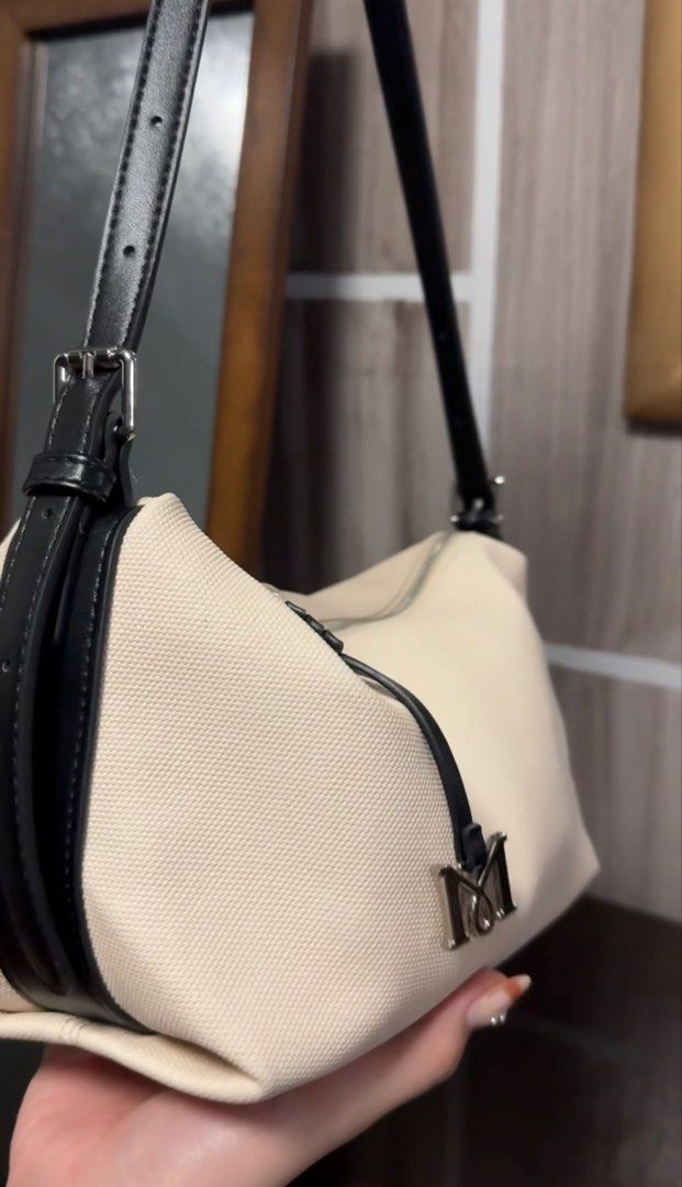 Mossdoom Canvas Shoulder Bag (Category: Shoulder Bags) located in Manila. Submitted by maudmd (Listing ID 1459635351, Image 3). Description: - Cream canvas shoulder bag - Black leather accents - Zipper closure - Adjustable strap - Metal 'M' logo charm - 'MOSS DOOM' embossed on the side - Clean and simple design - Great for everyday use.