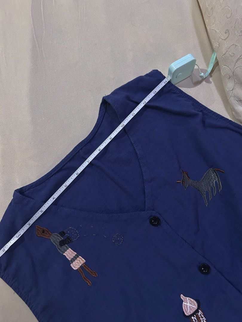 Navy Blue Embroidered Vest (Category: Others Tops) located in Cainta. Submitted by unboxingstuff (Listing ID 1459621651, Image 2). Description: - blue sleeveless linen vest - Features unique embroidery of animals and people - Classic button-up front design - Perfect for layering over any outfit - Estimated size M-L for comfortable fit.