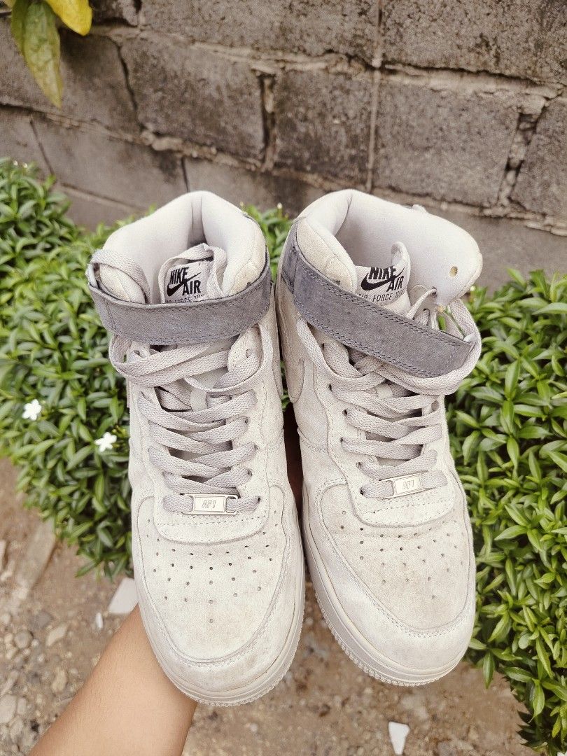 Nike Air Force 1 High Top Suede Sneakers (Category: Sneakers) located in Davao. Submitted by urhandsome_hb (Listing ID 1459566237, Image 1). Description: - Nike Air Force 1 High x Reigning Champ - Color: Light beige/grey suede - Classic Air Force 1 silhouette - Features a velcro ankle strap - Nike Air logo on tongue and heel - Perfect for everyday casual wear.