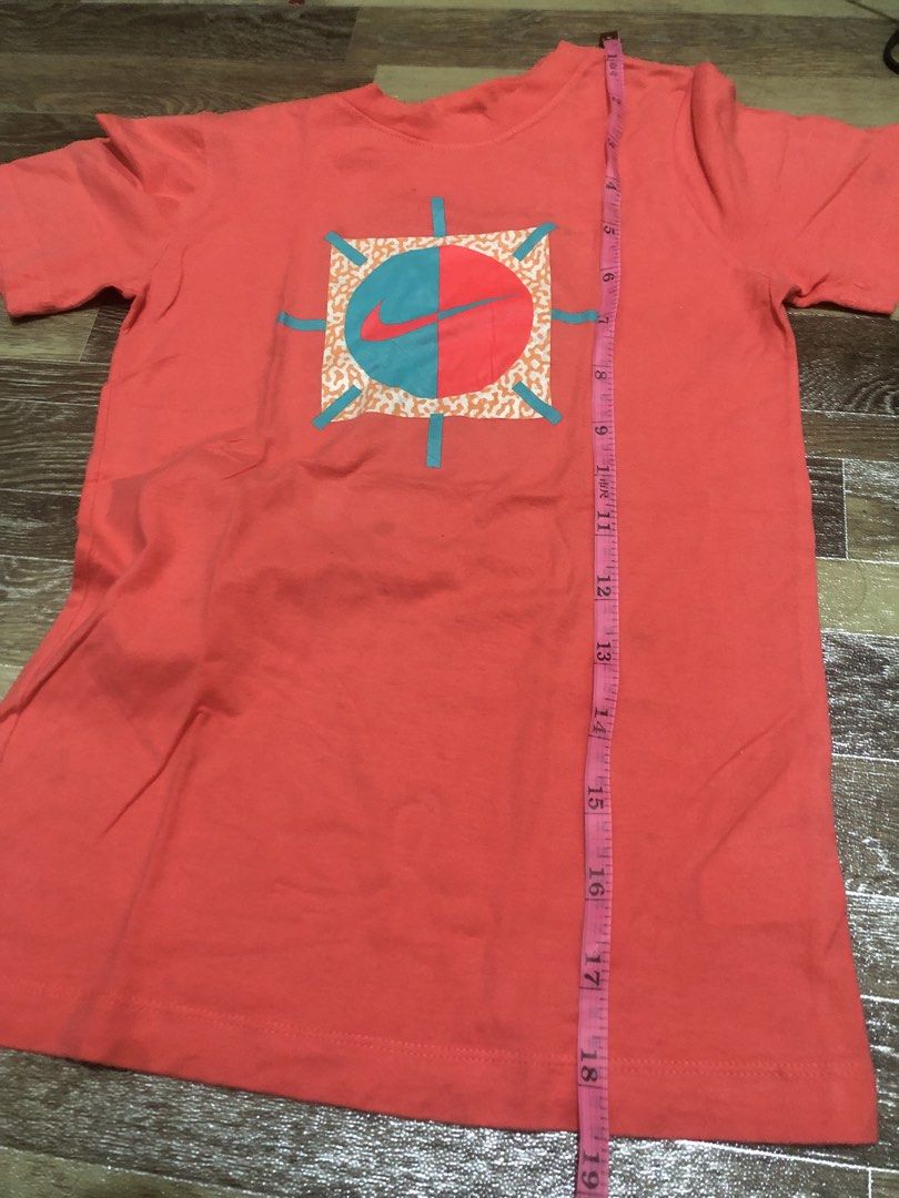 Nike T-Shirt Coral Graphic Tee (Category: Activewear) located in Manila. Submitted by tonettesells (Listing ID 1447833231, Image 3). Description: - Color: Coral - Brand: Nike - Size: L - Design: Unique circular graphic with teal and red sections, plus a Nike swoosh - Origin: Made in Mexico - Best for: Casual wear.
