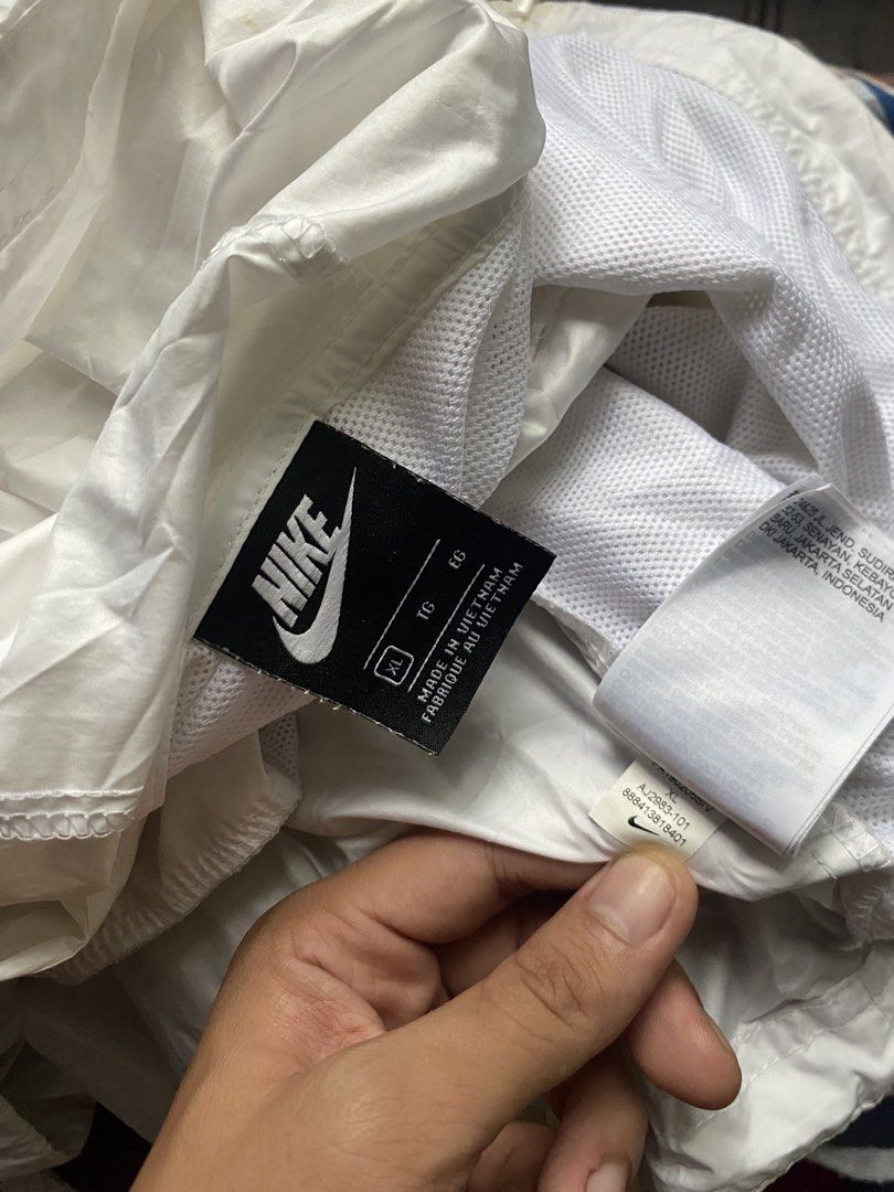 Nike White Hooded Windbreaker Jacket (Category: Coats, Jackets and Outerwear) located in Olongapo. Submitted by WAVYT (Listing ID 1459620405, Image 3). Description: - White Nike jacket with hood - Lightweight material, ideal for windy days or light rain - Front pockets for convenience - Drawstring at the hem for adjustable fit - Minor stains on sleeve (please check photos) - Made in Vietnam.