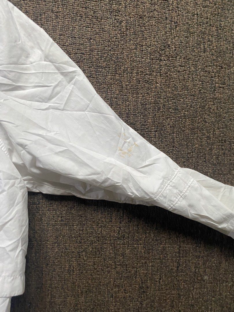 Nike White Hooded Windbreaker Jacket (Category: Coats, Jackets and Outerwear) located in Olongapo. Submitted by WAVYT (Listing ID 1459620405, Image 2). Description: - White Nike jacket with hood - Lightweight material, ideal for windy days or light rain - Front pockets for convenience - Drawstring at the hem for adjustable fit - Minor stains on sleeve (please check photos) - Made in Vietnam.