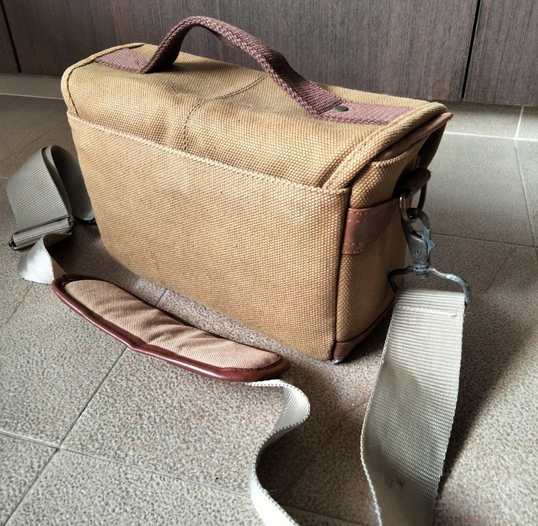 Nikon Canvas Camera Bag with Strap (Category: Camera Bags & Carriers) located in Singapore. Submitted by sunsettosunrise (Listing ID 1459577458, Image 2). Description: - Tan canvas Nikon camera bag - Main compartment with adjustable dividers - Padded shoulder strap included - Nikon logo on front flap - Ideal for camera and accessories - Minor signs of wear. Not for the fuzzies..
