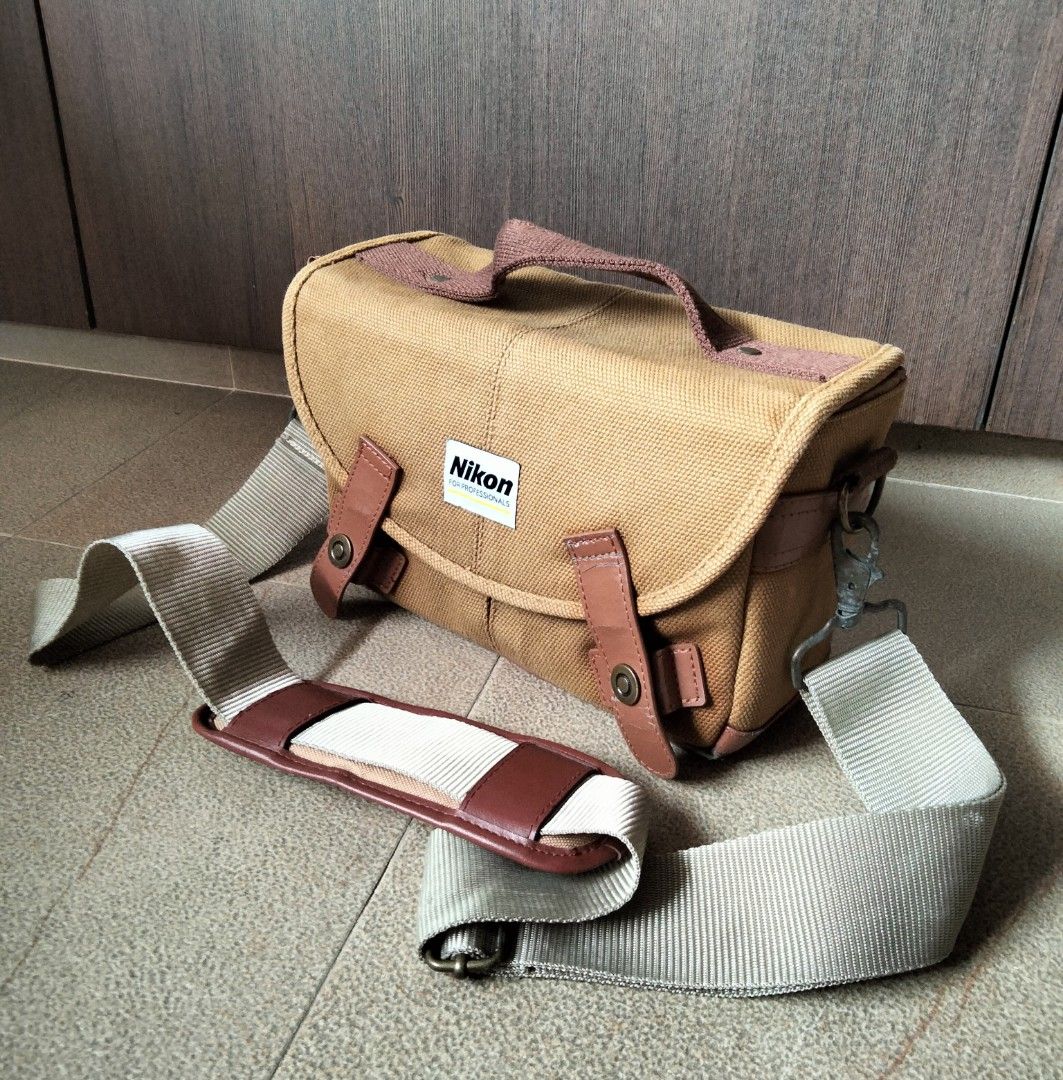Nikon Canvas Camera Bag with Strap (Category: Camera Bags & Carriers) located in Singapore. Submitted by sunsettosunrise (Listing ID 1459577458, Image 1). Description: - Tan canvas Nikon camera bag - Main compartment with adjustable dividers - Padded shoulder strap included - Nikon logo on front flap - Ideal for camera and accessories - Minor signs of wear. Not for the fuzzies..