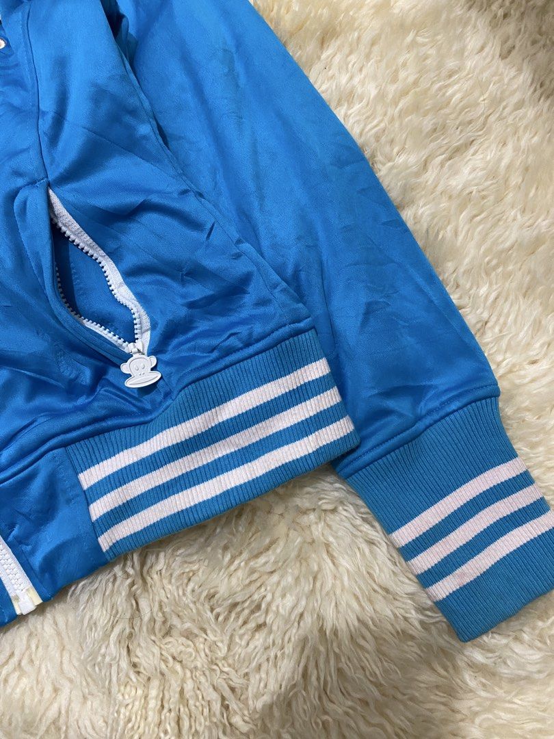 Paul Frank Blue Track Jacket with Julius Logo (Category: Coats, Jackets and Outerwear) located in Manila. Submitted by sepamorash53558 (Listing ID 1459689174, Image 3). Description: - Cool blue Paul Frank track jacket - Features iconic Julius monkey graphic on chest - Zip-up front with convenient pockets - Ribbed cuffs and hem with stylish white and pink stripes - Size: Medium (M) - Ideal for everyday casual wear.