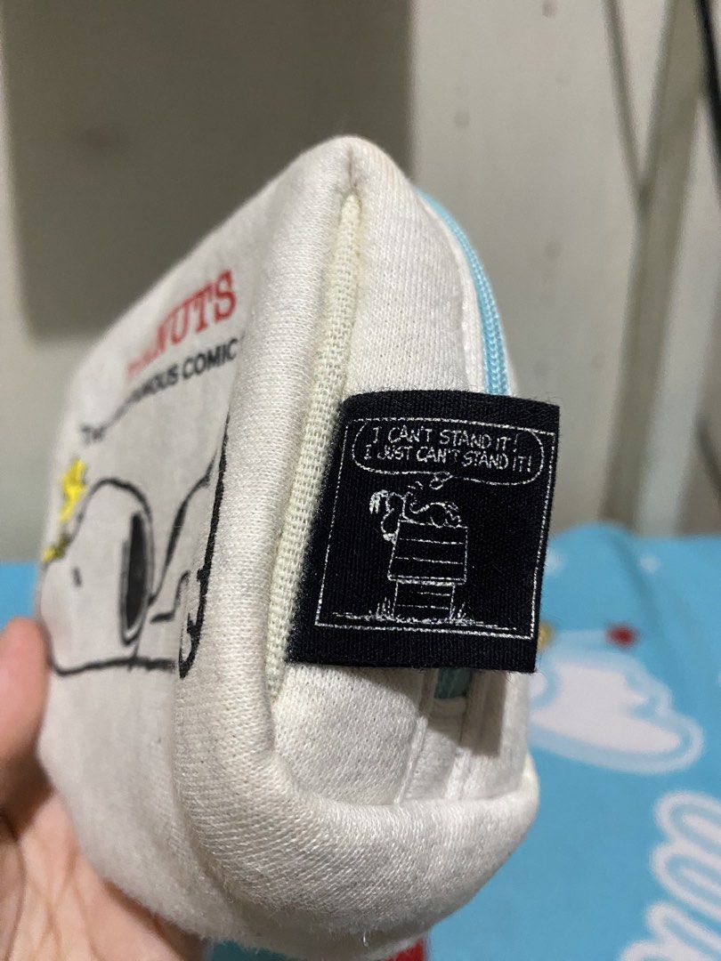 Peanuts Snoopy Pouch Cosmetic Bag (Category: Purses & Pouches) located in Manila. Submitted by resi.diaz (Listing ID 1459573986, Image 2). Description: - Adorable Peanuts pouch featuring Snoopy - "The World Famous Comic Strip" text on the front - Secure zipper closure with a light blue zipper - Small black tag with Snoopy quotes on the side - Perfect for storing makeup, stationery, or small essentials - Durable canvas material.