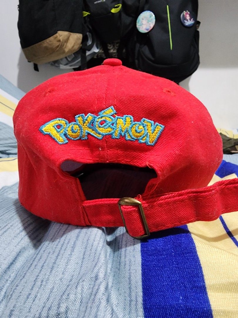 Pokemon Ash Ketchum Style Cap (Category: Caps & Hats) located in Meycauayan. Submitted by MP_Shop (Listing ID 1459577473, Image 3). Description: - Red and white cap - Green embroidery on the front - Yellow 'Pokemon' embroidery on the back - Adjustable strap with a metal buckle - Ideal for Pokemon enthusiasts.