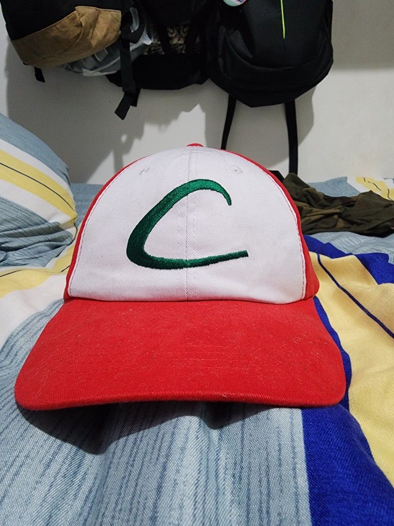Pokemon Ash Ketchum Style Cap (Category: Caps & Hats) located in Meycauayan. Submitted by MP_Shop (Listing ID 1459577473, Image 1). Description: - Red and white cap - Green embroidery on the front - Yellow 'Pokemon' embroidery on the back - Adjustable strap with a metal buckle - Ideal for Pokemon enthusiasts.