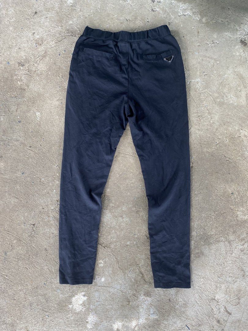 Prada Black Nylon Track Pants Joggers Size XL (Category: Joggers) located in Sinait. Submitted by rinzuthrift (Listing ID 1459528895, Image 1). Description: - Authentic Prada track pants - Size: XL - Material: Nylon and polyester blend - Features: Elastic waistband with drawstring, zipped front pockets - Iconic Prada triangle logo on the back pocket - Perfect for stylish casual wear - Missing zip puller.