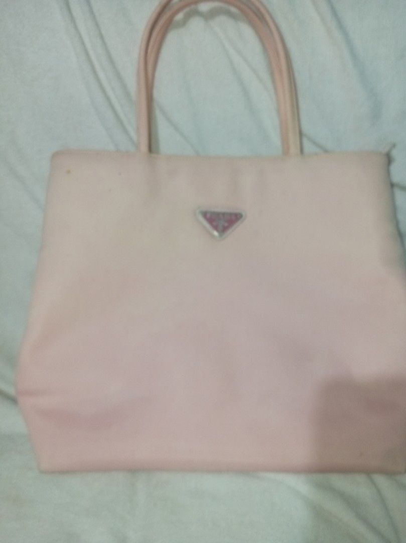 Prada Pink nylon bag (Category: Luxury Bags & Wallets) located in Malolos. Submitted by shoptokyothrift (Listing ID 1459559482, Image 1). Description: Vintage Prada Milano Pink Nylon Tote 🩷 Classic Prada Milano nylon tote with signature triangular logo, pink Prada lining & zip closure. Pre-loved/vintage with visible stains, discoloration and signs of use — please check all photos carefully. Please check photos/details before buying. Sold as is. 