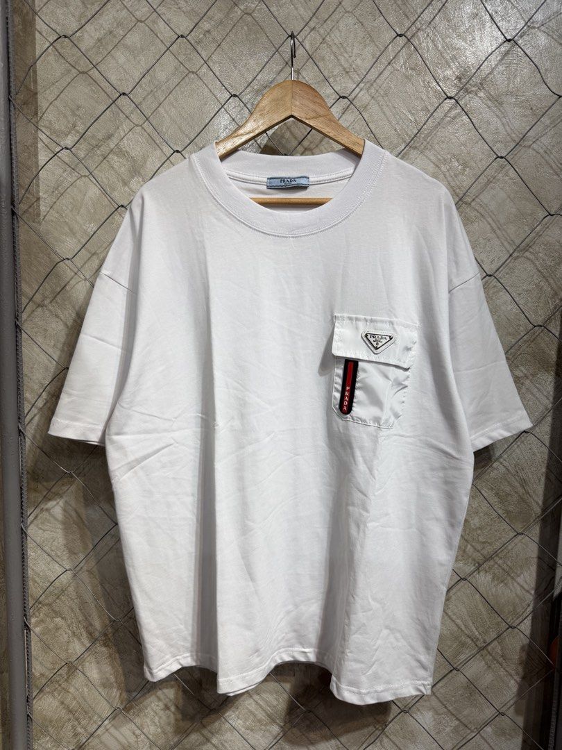Prada White Pocket T-Shirt (Category: Tshirts & Polo Shirts ) located in Manila. Submitted by ardobe.mnl (Listing ID 1459638813, Image 1). Description: Prada Plate Logo White Pocket Tee. Size: XXL Dimes: 24x30 Condition: Good asnew Flaw: None! Dm for inquiries! 🛒📥.