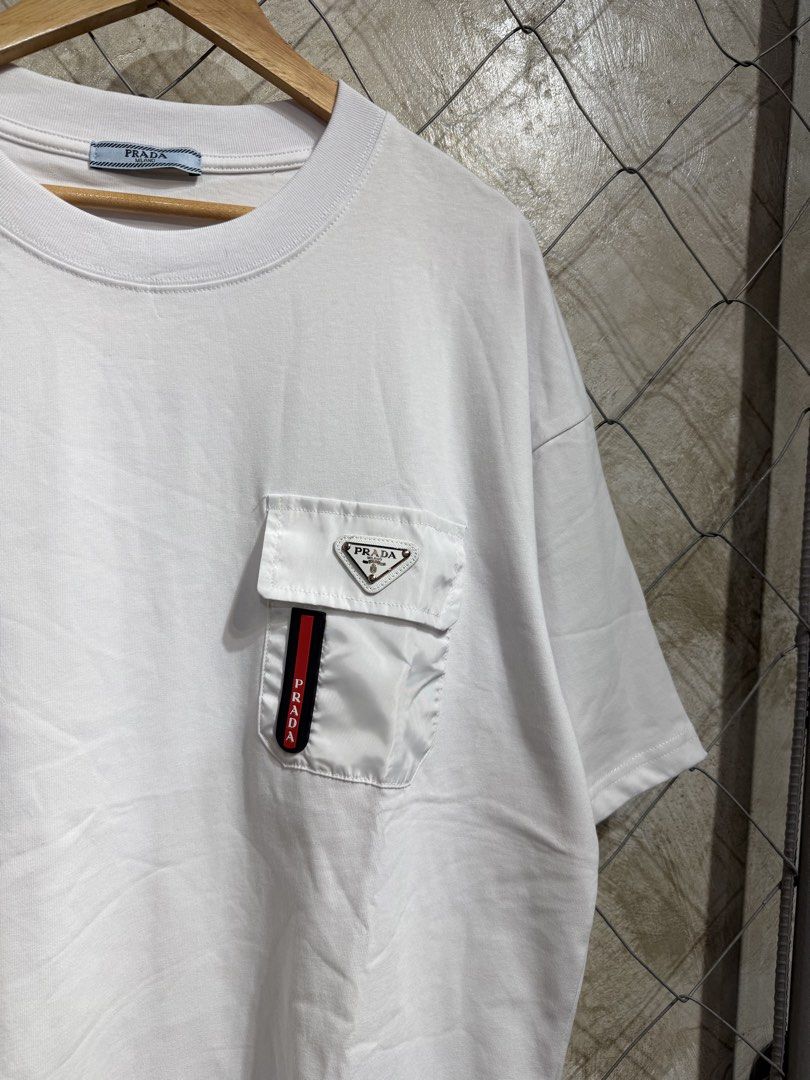 Prada White Pocket T-Shirt (Category: Tshirts & Polo Shirts ) located in Manila. Submitted by ardobe.mnl (Listing ID 1459638813, Image 2). Description: Prada Plate Logo White Pocket Tee. Size: XXL Dimes: 24x30 Condition: Good asnew Flaw: None! Dm for inquiries! 🛒📥.