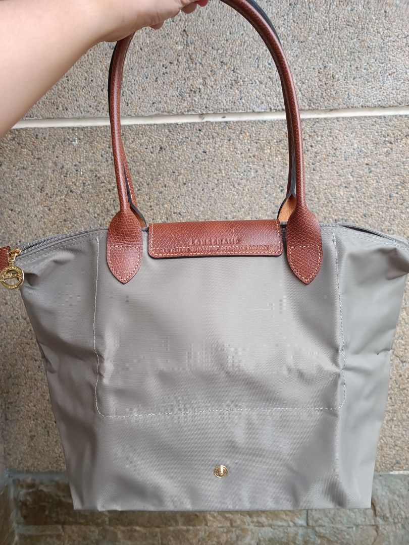 Preloved Authentic Longchamp Classic Small Long Handle Turtledove (Category: Luxury Bags & Wallets) located in Pasig City. Submitted by charmillee (Listing ID 1459504136, Image 2). Description: Preloved Authentic Classic Le Pliage •LongchampColor: Turtledove •Size: Small Long Handle Base Length: 10 inches (25 cm) Height: 10 inches (25 cm) Width / Depth: 5.5 inches (14 cm) Handle Drop: 8 inches (20 cm) •Condition: Preloved, like new, no issues •Je