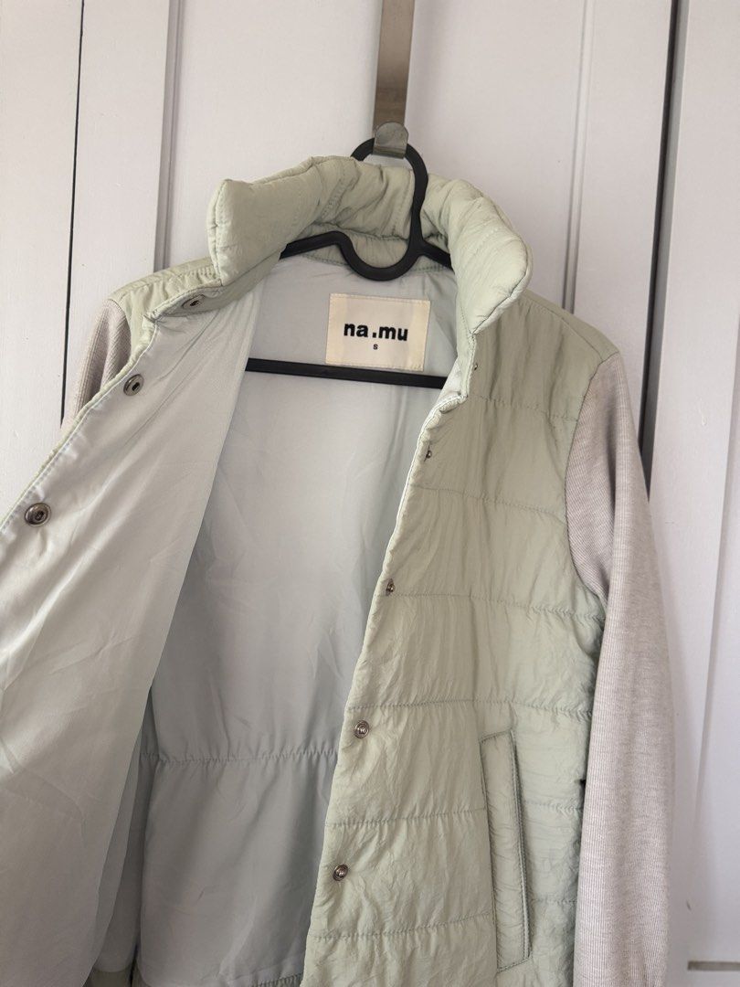 Puffer Jacket with Knit Sleeves (Category: Coats, Jackets and Outerwear) located in Baguio. Submitted by makemegeli (Listing ID 1459539297, Image 3). Description: Lightweight puffer jacket from na.mu. Features a pale green quilted body and contrasting knit sleeves. Snap button closure down the front. Elasticated drawstring at the waist for a cinched look. Two front pockets. Great layering piece for cooler weather..