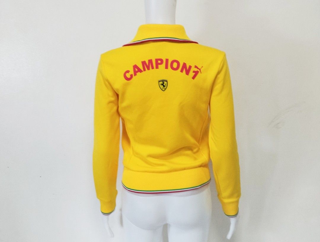 Puma Ferrari Track Jacket (Category: Coats, Jackets and Outerwear) located in Pateros City. Submitted by blashjunks.y2k (Listing ID 1459555927, Image 2). Description: Cool yellow Puma Ferrari track jacket. Features the Ferrari shield logo on the front and back. "Campioni" text with Puma logo on the back. Ribbed collar, cuffs, and hem with red, white, and green stripes. Zip-up front. Great for any Ferrari or Puma fan..