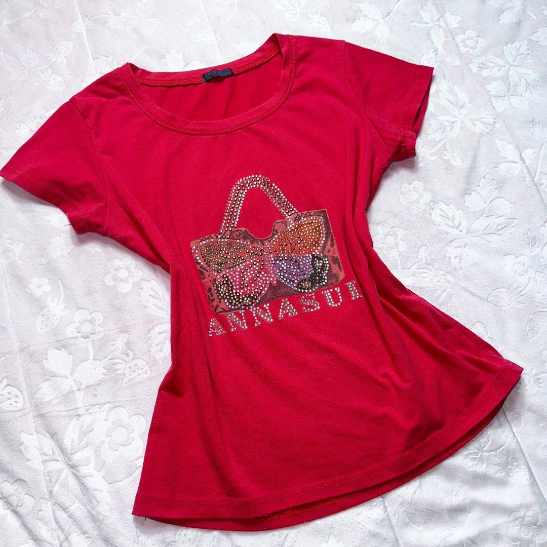 Red Rhinestone Fitted Tee (Category: Shirts) located in San Fernando. Submitted by rianne_von (Listing ID 1459613365, Image 2). Description: Size L on tag W: 16.5 in L: 20.5 in info: ✧ vibrant red fitted tee w/ statement handbag graphic + “FASHION” lettering ✧ multicolor rhinestone embellishments w/ sparkling chain detail for a Y2K look ✧ excellent thrifted condition; minimal discoloration observed, otherwise no major flaws ✧ color may vary sligh