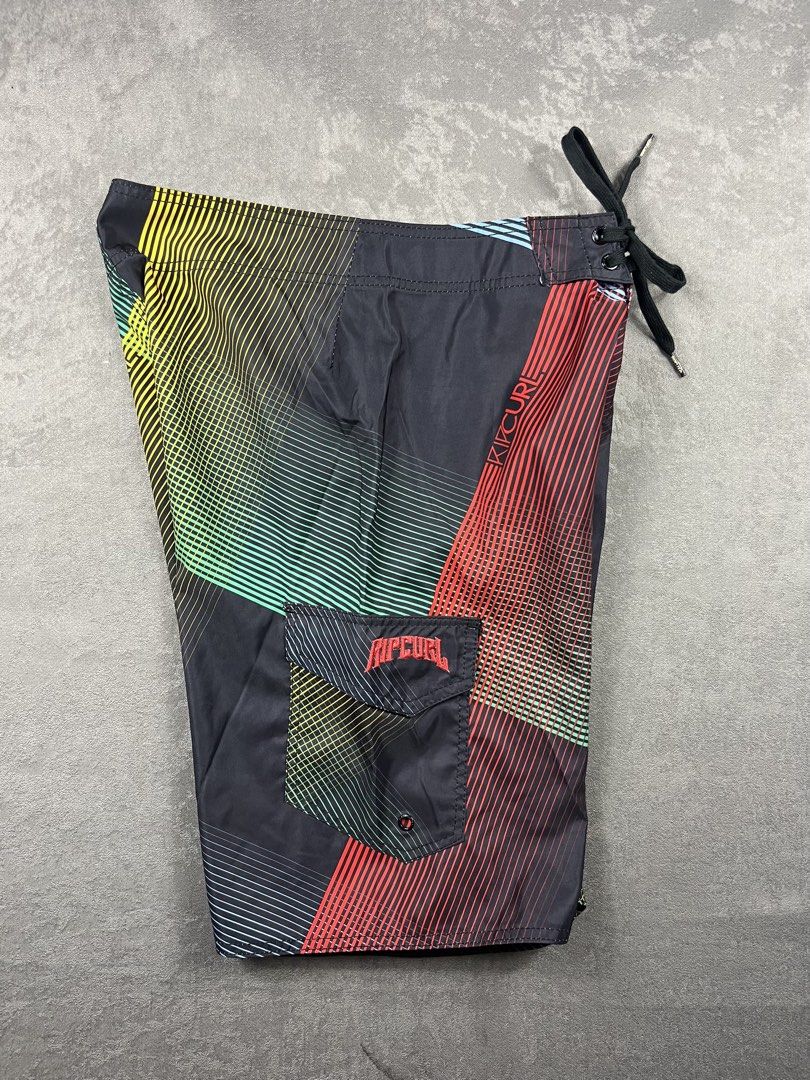 Rip Curl Men's Board Shorts Size 30 (Category: Swim Trunks & Board Shorts) located in Manila. Submitted by homegrwn_thrift (Listing ID 1459639451, Image 2). Description: - Brand: Rip Curl - Size: 30 fits to 33 - Color: Black with colorful geometric stripe pattern - Features: Drawstring waist, velcro back pocket - Ideal for: Swimming, surfing, beach trips.