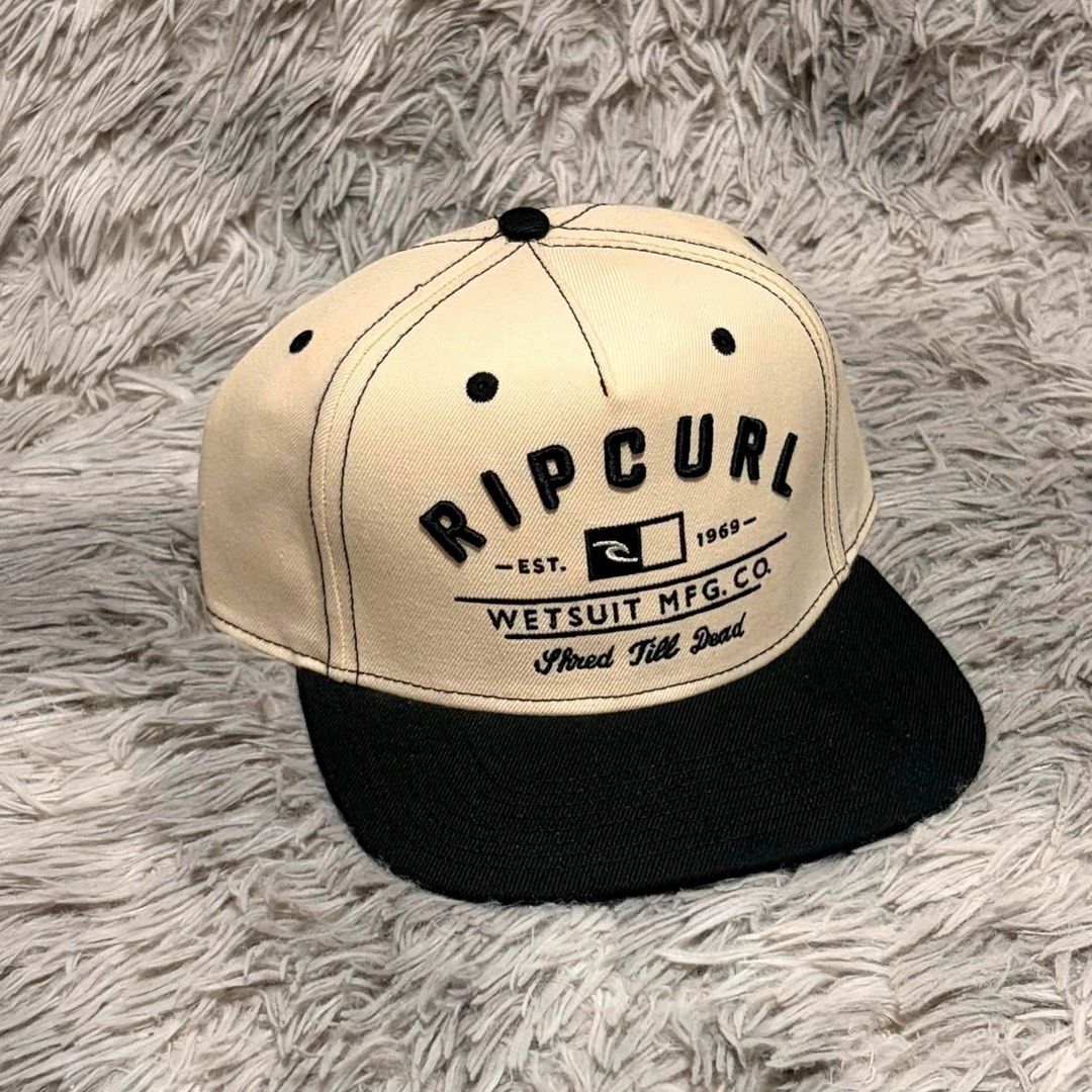 Ripcurl Snapback Cap - Wetsuit Mfg. Co. (Category: Caps & Hats) located in Santa Rosa. Submitted by klarksantos (Listing ID 1459600626, Image 3). Description: - Classic Ripcurl snapback cap - Beige crown with black brim - Features 'Wetsuit Mfg. Co.' logo and 'Shred Till Dead' text - Adjustable snapback closure for a comfortable fit - Ideal for casual wear, beach days, or a surf-inspired look.
