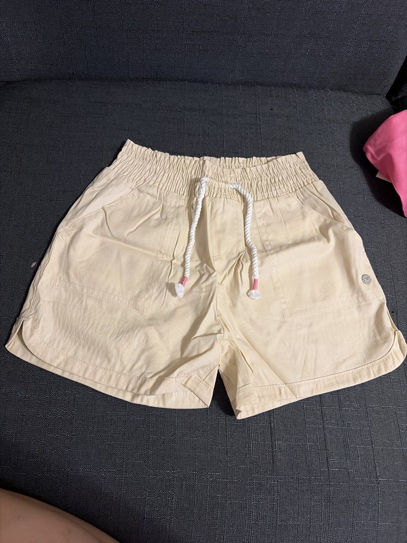 Roxy Beige Elastic Waist Drawstring Shorts (Category: Babies & Kids Fashion) located in Quezon City. Submitted by loca93 (Listing ID 1459677698, Image 1). Description: - Comfy beige shorts - Elastic waistband with drawstring - Front pockets - Small detail on the right side - Cute curved hem - Ideal for casual wear.