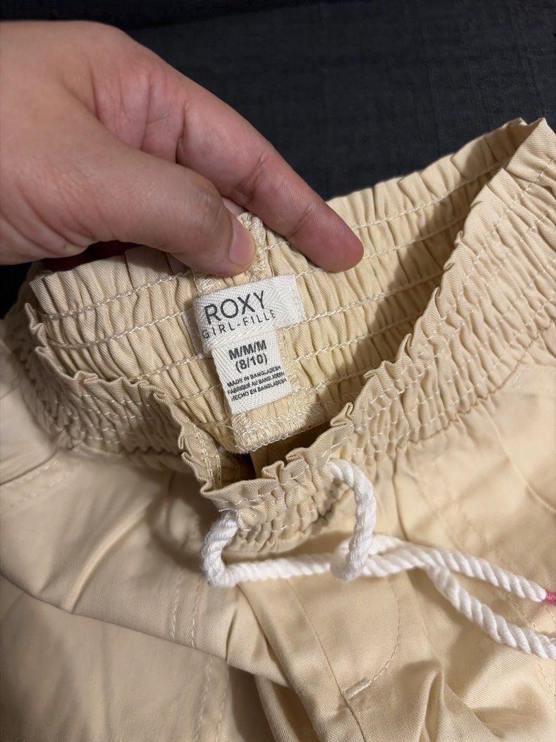 Roxy Beige Elastic Waist Drawstring Shorts (Category: Babies & Kids Fashion) located in Quezon City. Submitted by loca93 (Listing ID 1459677698, Image 2). Description: - Comfy beige shorts - Elastic waistband with drawstring - Front pockets - Small detail on the right side - Cute curved hem - Ideal for casual wear.