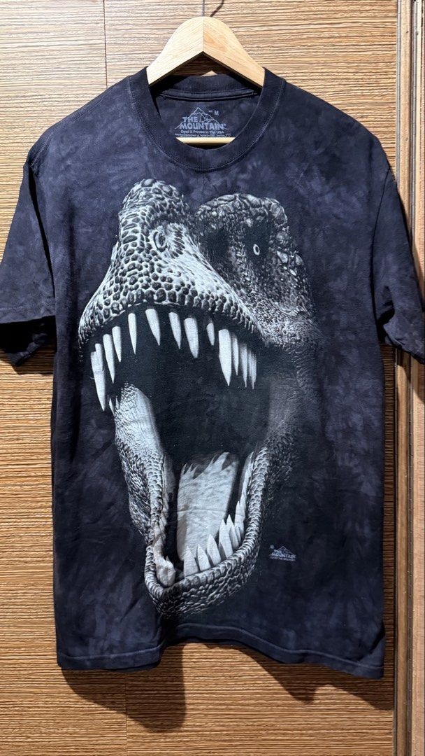 The Mountain Dinosaur T-Shirt Size M (Category: Tshirts & Polo Shirts ) located in Batangas. Submitted by cjayf (Listing ID 1459628979, Image 1). Description: - Cool tie-dye t-shirt - Features a fierce T-Rex graphic - Brand: The Mountain - Size: Medium - Material: 100% Cotton - Origin: Made in Mexico, dyed and printed in the USA - Unique all-over print - Perfect for dinosaur lovers.