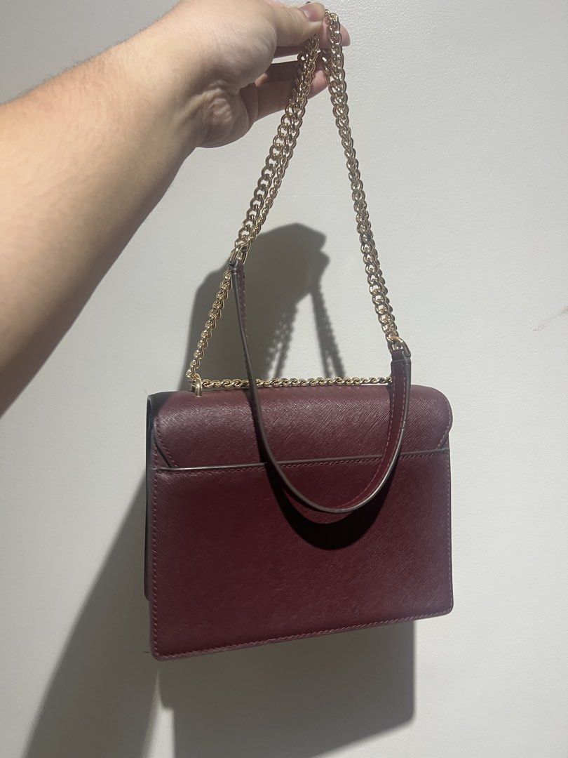 Tory Burch Burgundy Leather Chain Shoulder Bag (Category: Luxury Bags & Wallets) located in Santa Rosa. Submitted by pepperchill (Listing ID 1459676728, Image 2). Description: - Authentic Tory Burch shoulder bag - Rich burgundy color - Genuine Saffiano leather exterior - Elegant gold chain strap - Classic flap closure with signature Tory Burch logo - Versatile for day or evening wear - Perfectly sized for your essentials.