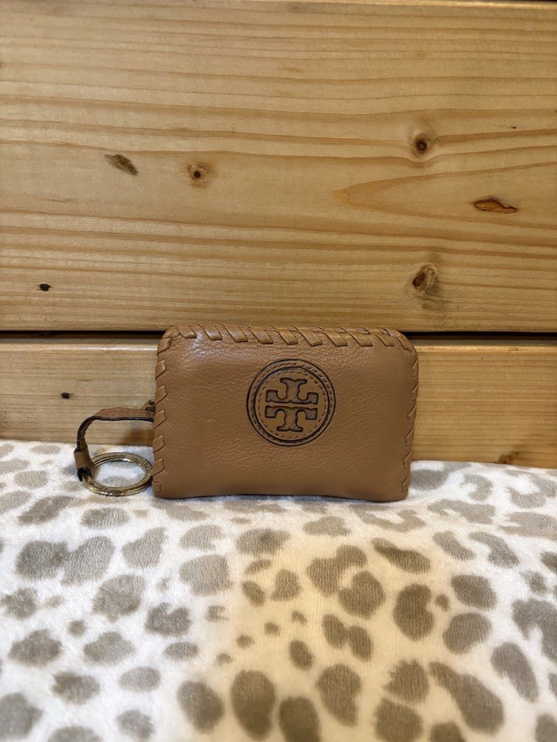 Tory Burch Leather Key Pouch (Category: Luxury Bags & Wallets) located in Caloocan City. Submitted by keenmountain-91832c (Listing ID 1459552800, Image 1). Description: - Authentic Tory Burch brown leather key pouch - Features signature embossed Tory Burch logo on the front - Elegant braided stitch detail along the edges - Comes with a small strap and keyring for easy attachment - Perfect for organizing your keys in style.