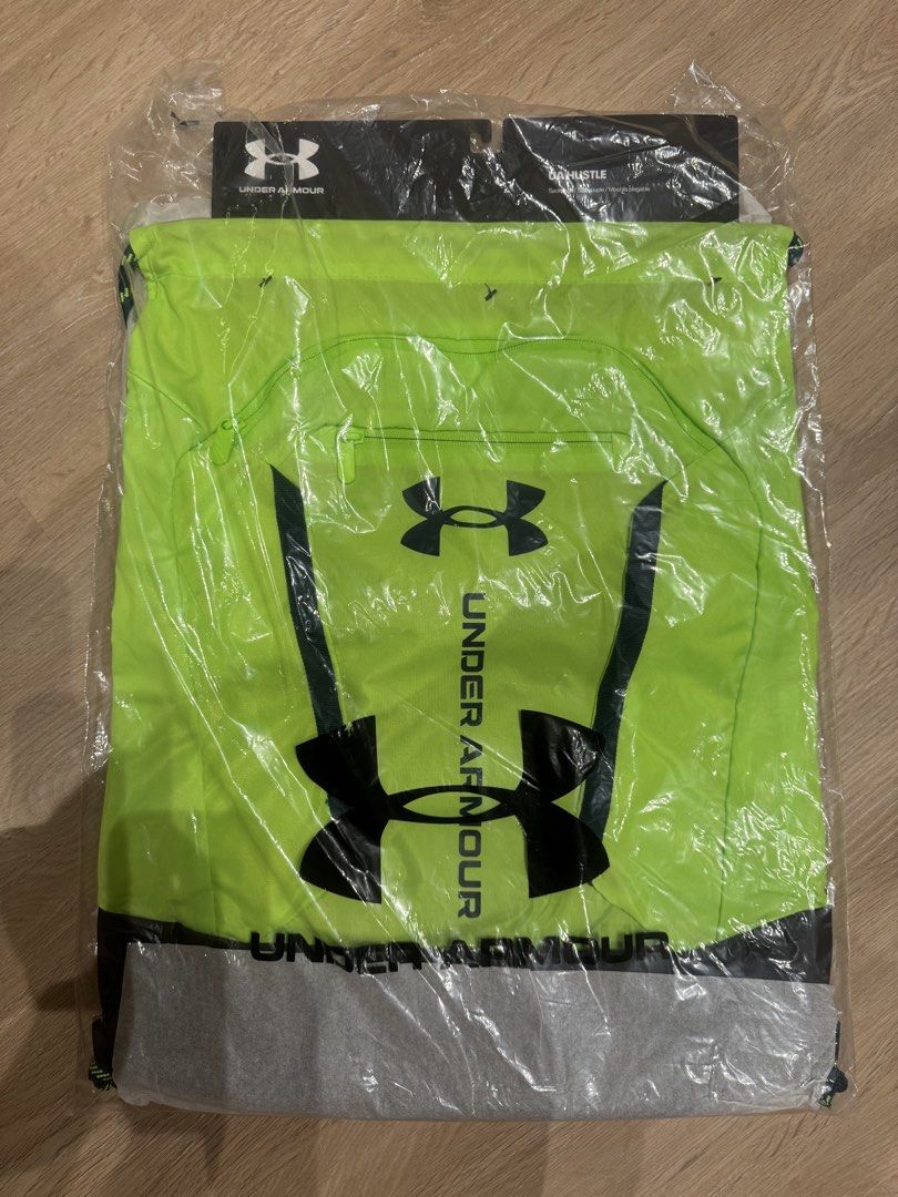 Under Armour drawstring backpack (Category: Backpacks) located in Puchong. Submitted by cninn (Listing ID 1459606049, Image 1). Description: - Bright neon green Under Armour drawstring bag - Features UA logo and branding - Convenient zippered pocket on the front - Ideal for gym, sports, or everyday use - Still in original packaging.