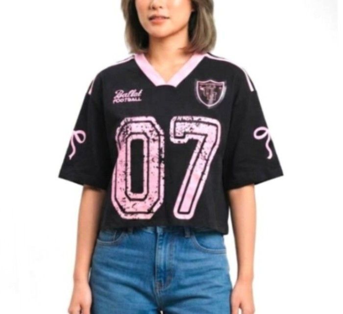 Varsity semi crop Bangkok Shirts (Category: Shirts) located in Quezon City. Submitted by panapton.ph (Listing ID 1459397577, Image 1). Description: -FLASH SALE ONLY 400 -Brandnew Bangkok Tops -Actual item post -Size fit 34 to 44bust -Branding and Origin: Includes a brand tag and hang tag reading "FLOWER" with a smiley face flower motif, indicating it is "Made in Korea". -Design and Details: Black short-sleeve jersey with contrasting pink V-neck c