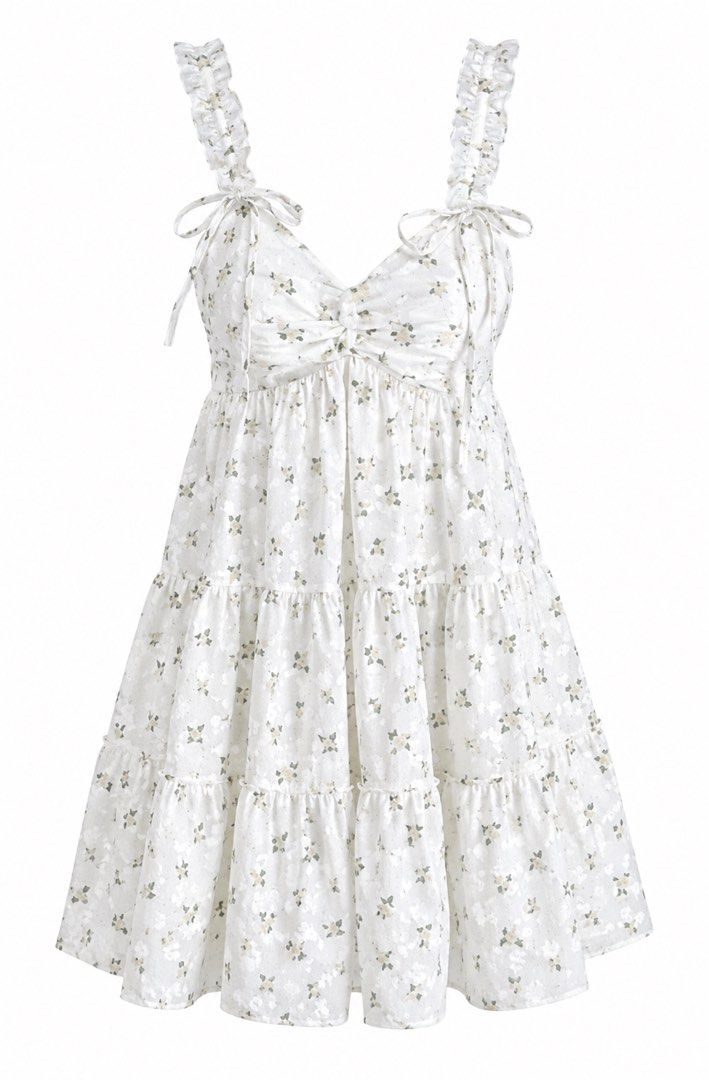 White Floral Tiered Ruffle Strap Mini Dress (Category: Dresses) located in Santa Barbara. Submitted by user82739292 (Listing ID 1459584963, Image 1). Description: - Adorable white mini dress with a charming floral print. - Features delicate ruffled straps for a feminine touch. - Stylish tie-front detail adds a flattering silhouette. - Flowy tiered skirt for a playful and breezy look. - Ideal for picnics, casual outings, or a day at the beach. - V