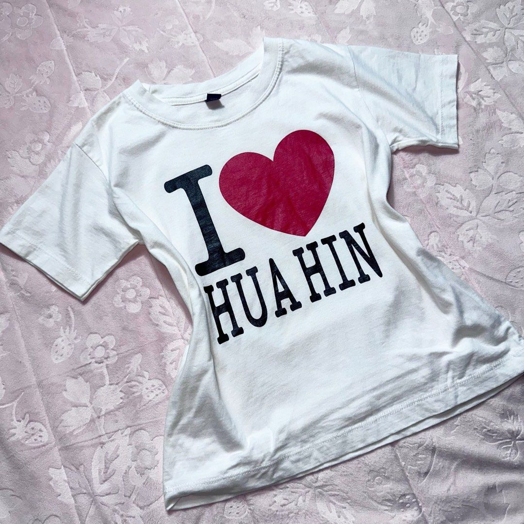 White Graphic Baby Tee (Category: Shirts) located in San Fernando. Submitted by rianne_von (Listing ID 1459613030, Image 2). Description: Size 15 on tag W: 14.8 in L: 18 in info: ✧ white fitted baby tee w/ bold “I ♥ HUA HIN” statement graphic ✧ contrast black lettering + vibrant red heart for a playful tourist/Y2K look ✧ excellent thrifted condition; no holes, stains, or major flaws observed ✧ color may vary slightly due to lighting.