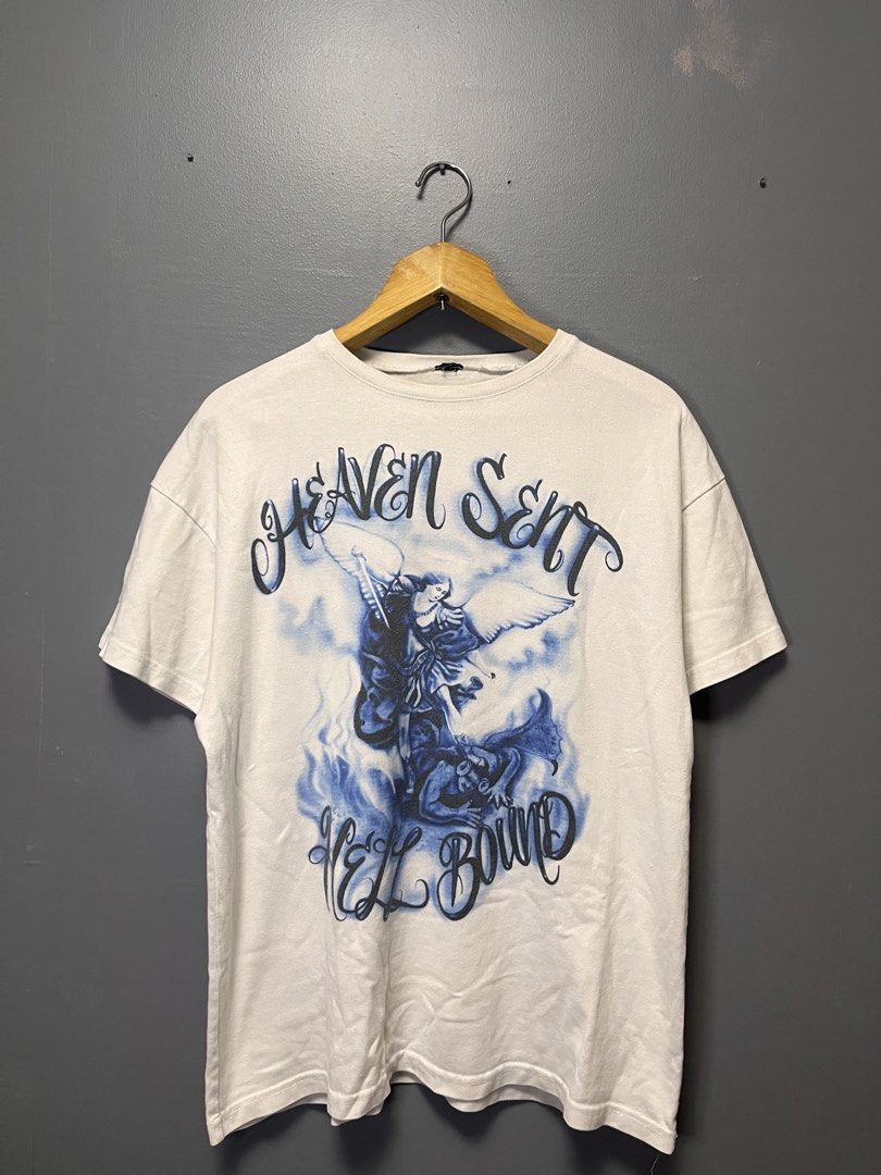 White "Heaven Sent Hell Bound" Graphic T-Shirt (Category: Tshirts & Polo Shirts ) located in Cabuyao City. Submitted by bulandos (Listing ID 1459632493, Image 1). Description: - White graphic t-shirt - "Heaven Sent Hell Bound" design - Features an angel battling a demon graphic - Ideal for casual everyday wear.