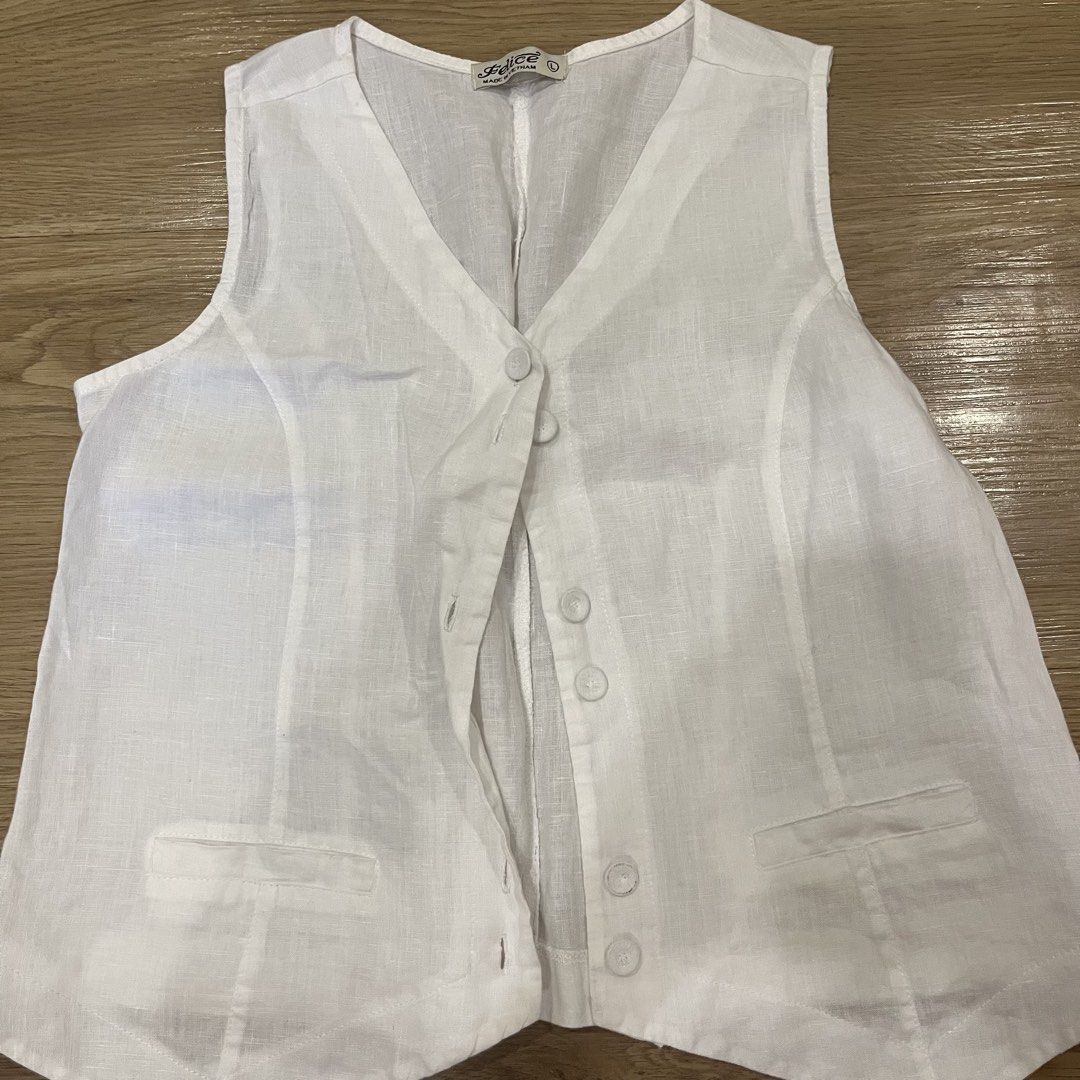 White Linen Vest by Felice (Category: Sleeveless) located in Paranaque City. Submitted by kalattt (Listing ID 1459545733, Image 1). Description: - Belice white linen vest - V-neckline with button-up front - Two front pockets - Sleeveless design - Made in Vietnam - Lightweight and breathable material - Ideal for layering over tops or dresses.