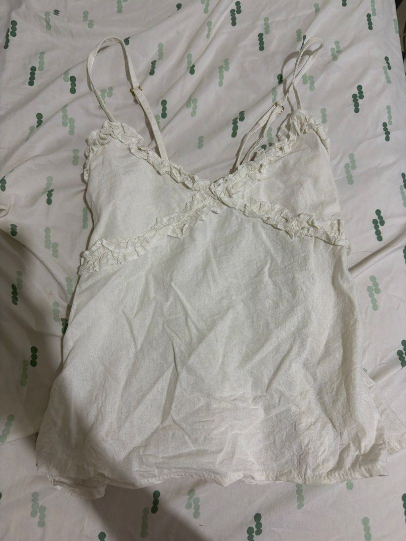 White Ruffled Cami Top with Adjustable Straps (Category: Blouses) located in Bansud. Submitted by youngtiger_4a33c1 (Listing ID 1459598275, Image 1). Description: - Cute white cami top - Features ruffles along the neckline and straps - Adjustable straps with a small gold buckle - Lightweight and breathable fabric - Ideal for layering or wearing on its own - Versatile: easily pairs with shorts or skirts RFS: Size doesn’t fit.
