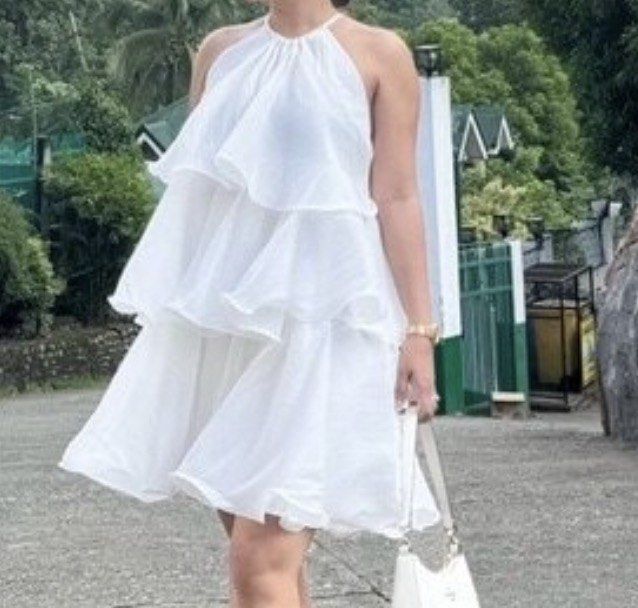 White Tiered Ruffle Halter Neck Mini Dress (Category: Dresses) located in Manila. Submitted by oohwwella (Listing ID 1459578626, Image 3). Description: - Cute white mini dress - Tiered ruffle details - Halter neck with tie closure - Lightweight and flowy fabric - Ideal for summer events and beach trips - Versatile for dressing up or down - Flattering and lovely to wear.