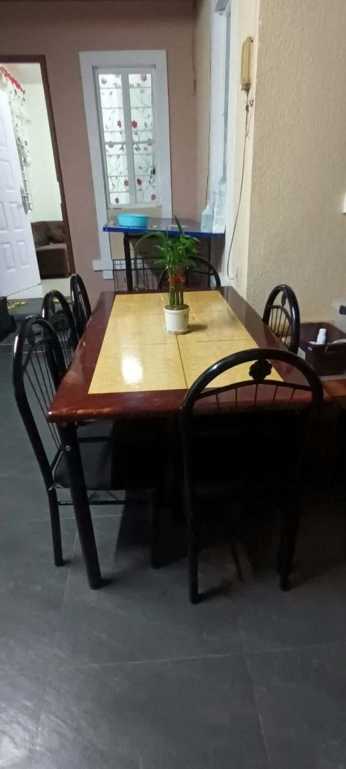 Wooden Dining Table with 4 Chairs (Category: Tables & Sets) located in Makati City. Submitted by donald1983 (Listing ID 1459570092, Image 2). Description: - Rich brown wooden dining table - Unique tiled centerpiece - Includes 4 sturdy metal frame chairs with black backs - Ideal for small to medium dining spaces - Note: Plant and glass decor not included.
