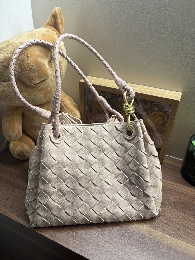 Woven Shoulder Bag with Pouch and Strap (Category: Shoulder Bags) located in Manila. Submitted by trishsells.stuff (Listing ID 1459527456, Image 3). Description: - Light pink woven shoulder bag - Comes with a matching pouch - Detachable crossbody strap included - Elegant gold hardware detail on the front - Stylish braided straps - Spacious interior - Versatile for everyday use or evening events.