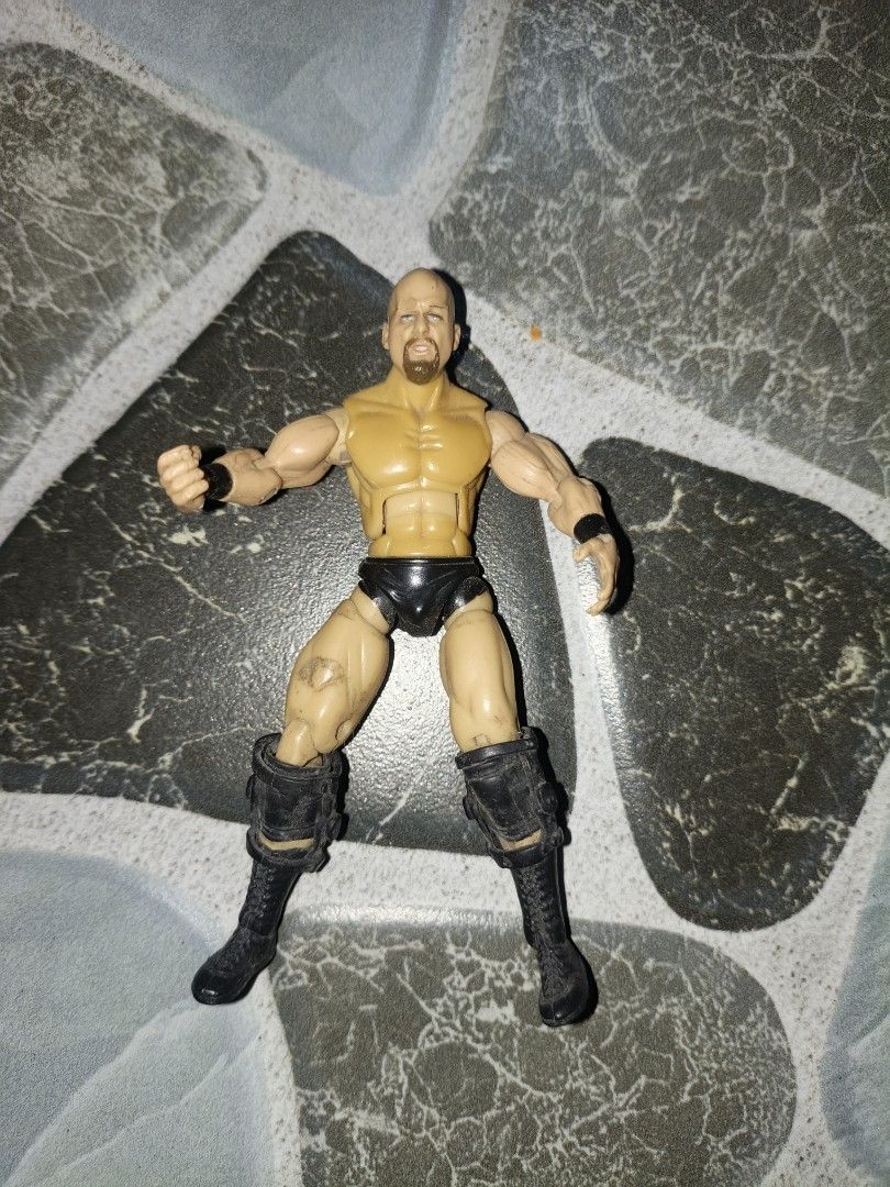 WWE Stone Cold Steve Austin Action Figure (Category: Figurines & Statues) located in Narvacan. Submitted by picky_looter (Listing ID 1459634373, Image 1). Description: - WWE Action Figure: Stone Cold Steve Austin - Size: Approximately 6 inches tall - Features: Fully articulated joints for dynamic posing - Condition: Minor scuffs on legs and boots - Ideal for: Wrestling fans and collectors.