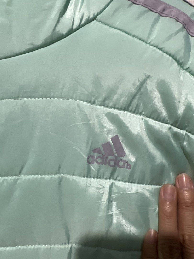 Adidas Puffer Jacket Mint Green (Category: Coats, Jackets and Outerwear) located in Rizal. Submitted by 411tatedgirl (Listing ID 1459795204, Image 2). Description: - Lightweight Adidas puffer jacket - Color: Mint green with grey sleeve stripes - Features a hood and full zip closure - Made in Vietnam - Material: 100% recycled polyester - Ideal for layering or cooler weather - XXS to Medium Adult Womens.