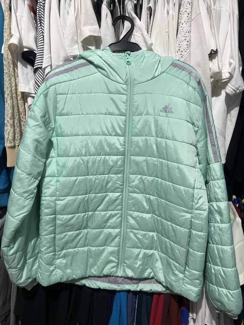 Adidas Puffer Jacket Mint Green (Category: Coats, Jackets and Outerwear) located in Rizal. Submitted by 411tatedgirl (Listing ID 1459795204, Image 1). Description: - Lightweight Adidas puffer jacket - Color: Mint green with grey sleeve stripes - Features a hood and full zip closure - Made in Vietnam - Material: 100% recycled polyester - Ideal for layering or cooler weather - XXS to Medium Adult Womens.