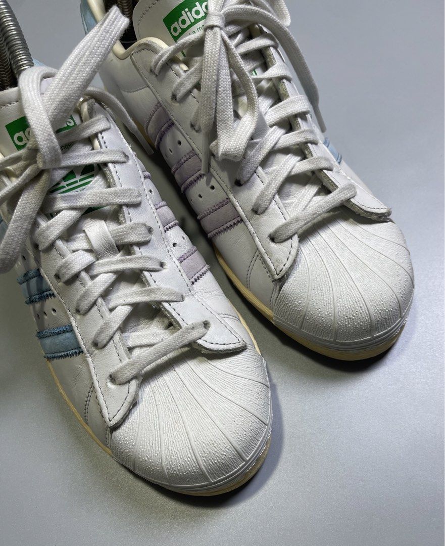 Adidas Superstar White Light Blue Stripes Shell Toe Sneakers (Category: Sneakers) located in Zamboanga. Submitted by laffthrift_23 (Listing ID 1459873785, Image 2). Description: - Classic Adidas Superstar sneakers - White leather with light blue stripes - Iconic shell toe design - Soles show some yellowing from age - Perfect for casual wear and vintage style.